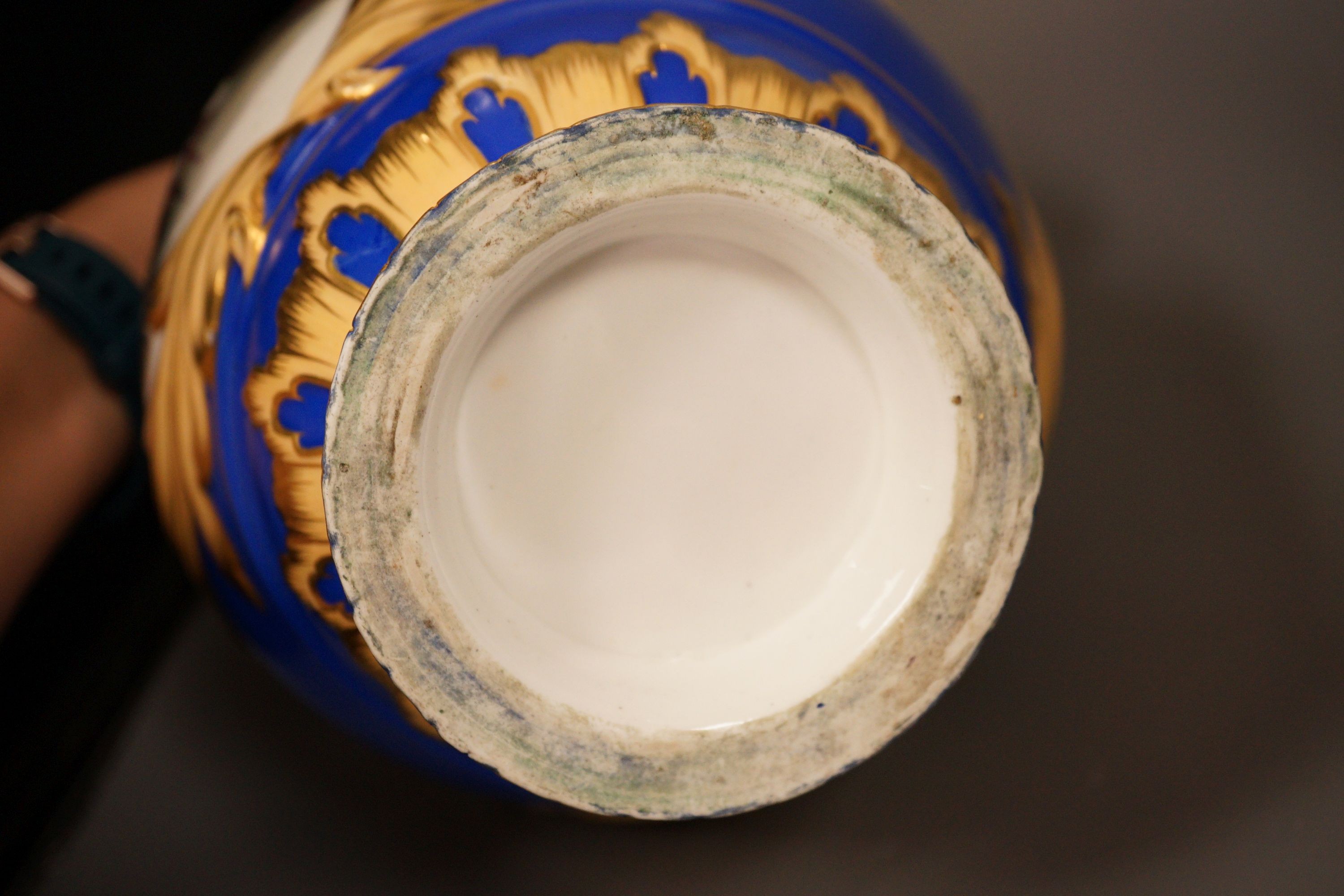 A pair of English bone China lidded two-handled vases, painted with river landscapes, within blue and gilt fields, circa 1840, 33cm
